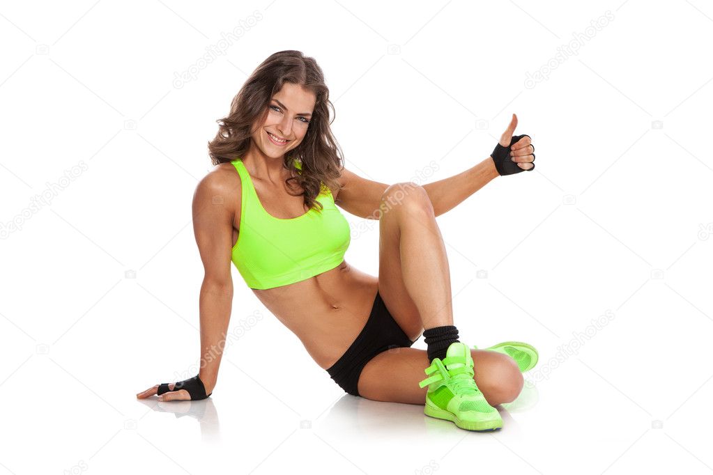 attractive fit women sitting, smiling and showing thumbs up