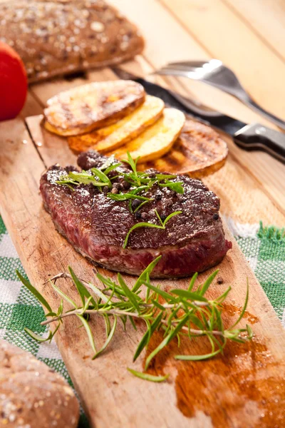 Bife grelhado, batatas assadas, legumes — Fotografia de Stock