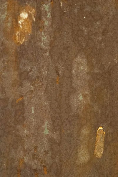Metal plaka zamanla aşınmış kahverengi ve bakır tonlarıyla.