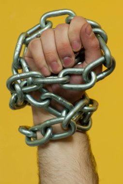 Özgürlük, kölelik, direniş kavramı... Kalın bir zincirle yumruk yapan bir el.