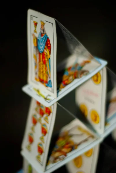 Zirvedeki krala odaklanan bir iskambil kalesi, şatonun düşecekmiş gibi görünmesini sağlıyor.