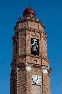 Mavi gökyüzünün üzerindeki bir köyün çan kulesi