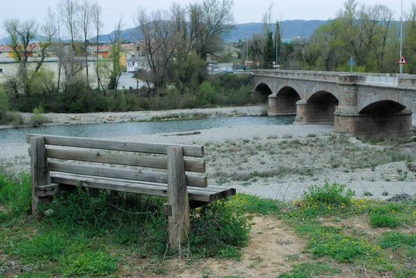 Kırsal bir alana bağlanan nehre bakan bankta.