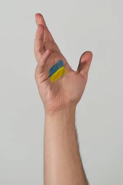 乌克兰国旗的颜色被画在一只手的手掌上 作为他们遭受战争的象征 — 图库照片