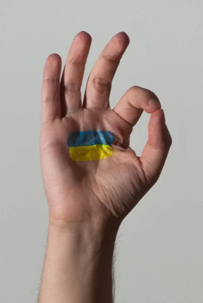 乌克兰国旗的颜色被画在一只手的手掌上 作为他们遭受战争的象征 — 图库照片