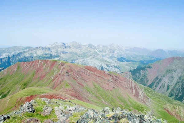 Berrak gökyüzü ve kayalık önplanı olan dağlık vadi manzarasının güzel manzarası