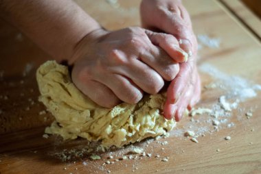 Baker 'ın elleri tahtanın üzerinde un hamuru üzerinde çalışıyor.