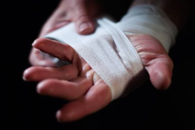 Beyaz bandajlı bir boksörün elleri bir spor savaşına hazırlanıyor.