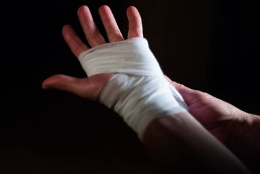 Beyaz bandajlı bir boksörün elleri bir spor savaşına hazırlanıyor.