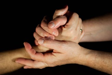 Hands of husband and wife lovingly holding hands while married for many years