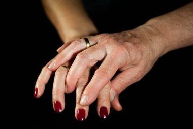 Yıllarca evli kalırken sevgi dolu bir şekilde el ele tutuşan karı kocanın elleri.