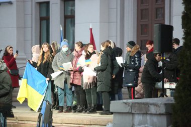 DAUGAVPILS, LATVIA - 2 Mart 2022. Rusya 'nın askeri saldırısına karşı Daugavpils' te (Letonya) Ukrayna 'yı destekleme eylemi. Pankartlı ve bayraklı insanlar