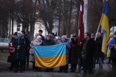 DAUGAVPILS, LATVIA - 2 Mart 2022. Rusya 'nın askeri saldırısına karşı Daugavpils' te (Letonya) Ukrayna 'yı destekleme eylemi. Pankartlı ve bayraklı insanlar