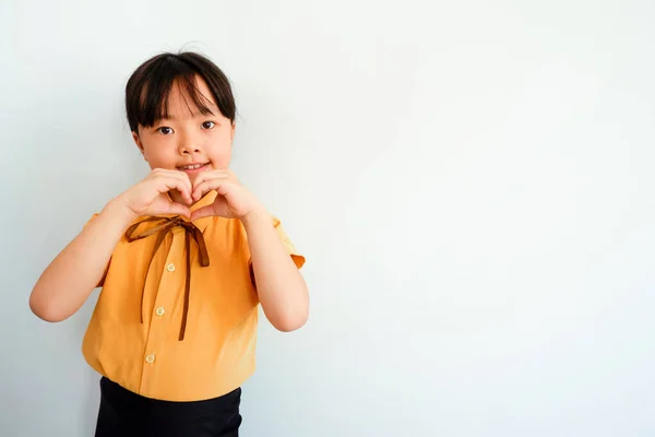 Фото Усміхненої Дівчини Показує Знак Кохання Жовтій Сорочці Гіпсовому Фоні — стокове фото