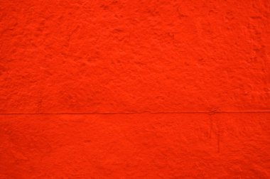 Kırmızı, sert beton bir duvar örneği.