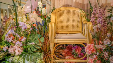 Çiçek aranjmanlarının arka planında yeni evliler için boş buketli sandalyeler var..