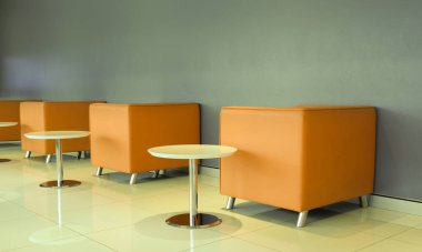 Bir sıra alçı duvarlı sandalye ve cam kenarlı masa sahne için arka plan görevi görür.