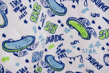 Kumaş deseni kumaş üzerinde resimler ve harflerle basılmış..