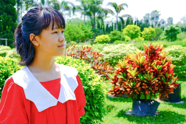赤いシャツを着た若い女性が屋外公園で休暇を過ごしています — ストック写真