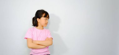 Kolları pembe tişörtlü Asyalı bir kızın yarı vücut fotoğrafı..