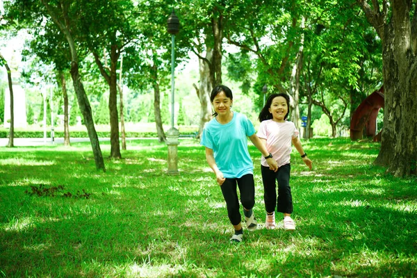 園内をジョギングする2人の女の子が微笑む — ストック写真