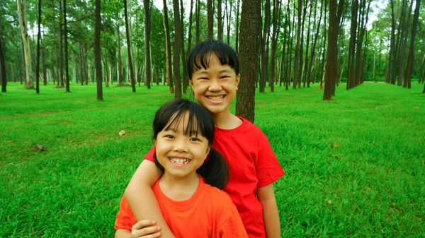 屋外公園でリラックスして遊んでいる2幸せな笑顔の女の子の写真の背景 — ストック写真