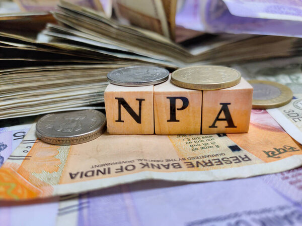 Коломна, Индия, дата проведения - 2021 год. NPA или неработающих активов буквами на деревянные бусины или блок с индийской рупии банкноты и монеты.