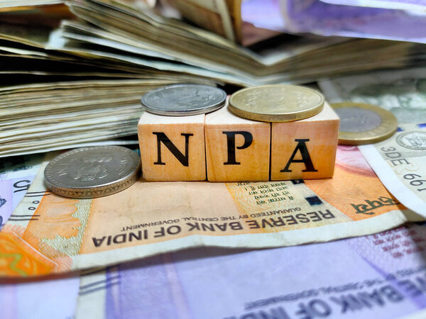 Коломна, Индия, дата проведения - 2021 год. NPA или неработающих активов буквами на деревянные бусины или блок с индийской рупии банкноты и монеты.