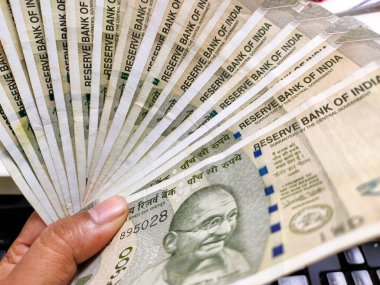 Kolkata, Hindistan, tarihi 15.09.2021. Bir sürü 500 rupi nakit ya da kağıt oynamak gibi bir adamın elindeki banknotlar..