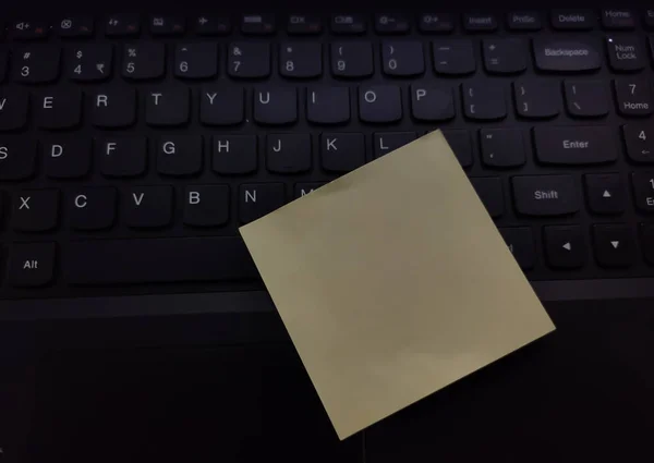 Laptop tuşuna iliştirilmiş boş yapışkan not içeriden bir mesaj taşıyor