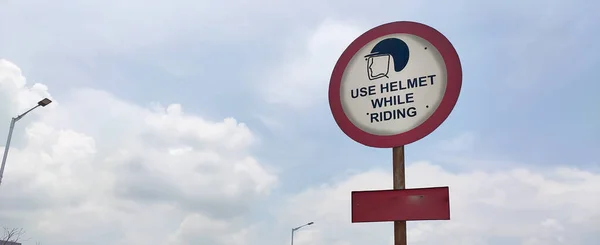 Yol üzerindeki trafik kuralları ve tabelalar sürücü için sürerken kask kullanımı uyarısı içindir..