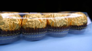 Altın renkli çikolatalar kutuya konur..