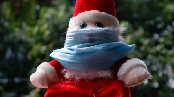 25 Aralık Noel günü Corona virüsünden korunmak için yüzünde cerrahi maske olan Noel Baba..