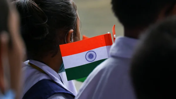 Kolkata, India, dated 15/08/2022. Concept of every child should go to school. Children in school uniform hoisting indian flag during independence day at school.