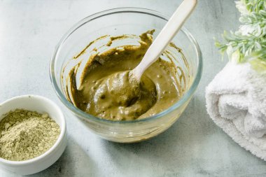 Henna kuru pudra, kına rehidratlı cam kase, mermer bir paspasın üzerinde beyaz terry havlu. Organik çevre dostu boyalardan ev yapımı saç boyası.