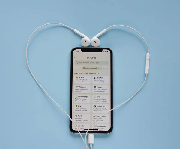 Moskova, Rusya - 4 Mart 2021: Kulüp uygulaması iPhone 'da ve kulaklıklar mavi arka planda açıldı. Farklı odalara sahip yeni sosyal medya uygulaması ve insanlar arasındaki en iyi bağlantılar için moderatörler, sözlü iletişim. Pankart