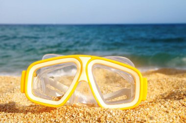 Diving goggles. Yellow color. Against the backdrop of the sea and sand.