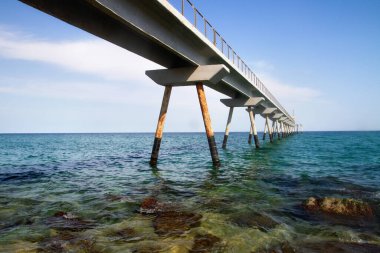 Waves, sea, beach, clear water. Bridge in the water.