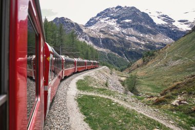 Bernina express on Switzerland. It is landmark of Swiss Alps. Nice Alpine landscape in summer. Red glacier train on railroad bridge in mountains. Scenic panoramic view of railway