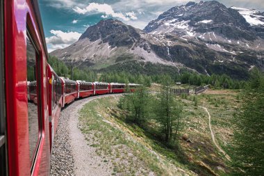 Bernina express on Switzerland. It is landmark of Swiss Alps. Nice Alpine landscape in summer. Red glacier train on railroad bridge in mountains. Scenic panoramic view of railway