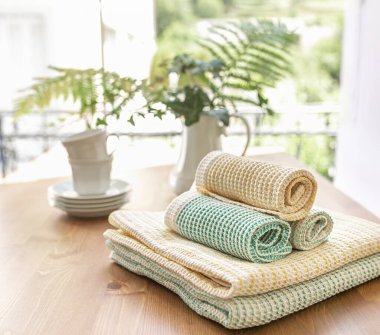 Pencereden sabah manzarası. Güzelce katlanmış mutfak havluları masada, kahve ve çay da kahvaltıda..