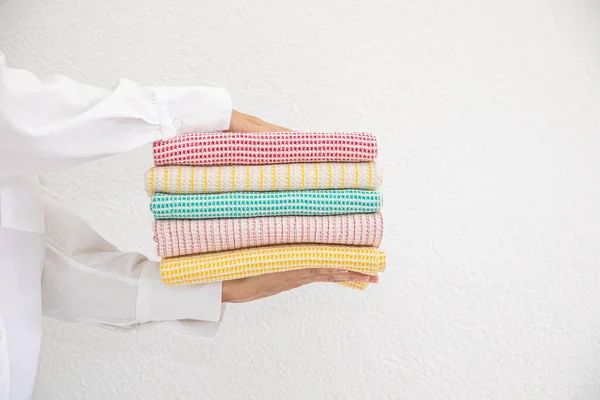 在白色背景的天然材料篮子里拿着一系列毛巾的女人 通风和时尚的厨房纺织品 — 图库照片