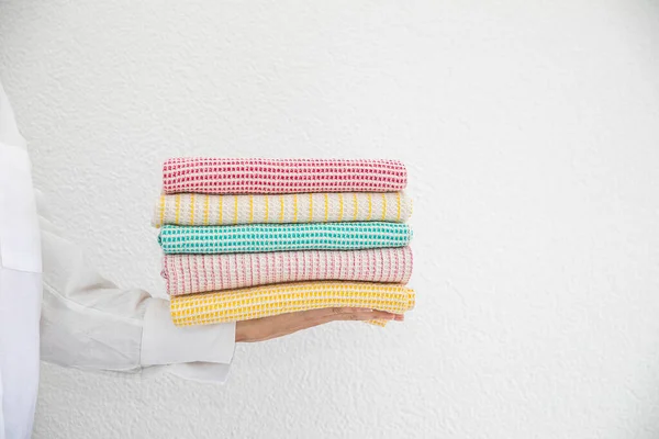 白い背景に天然素材で作られたバスケットにタオルのコレクションを持つ女性 柔らかく 風通しの良いスタイリッシュなキッチンテキスタイル — ストック写真