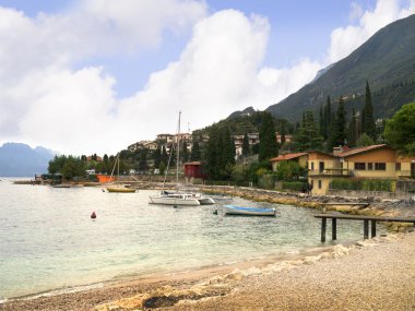 Beach at malcesine on Lake Garda in the Italian Lakes in the north of Italy clipart