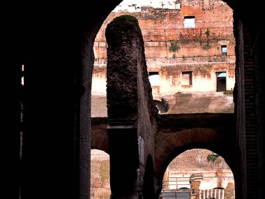 Bölgenin sahne arkasındaki Colosseum 'un kemerlerine bakıyorum. Şimdi mahvoldu ama bir zamanlar gladyatörler, aslanlar, Hristiyanlar, sahne makineleri ve aksesuarları vardı. Kolezyum, İtalya 'nın Roma şehrinin simgesel sembolüdür.   
