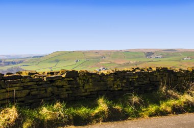 Moss Covered Drystone Wall built without cement that lasts for hundreds of years in Lancashire England. THis one is above the Rossendale Valley at Rawtenstall in lancashire clipart