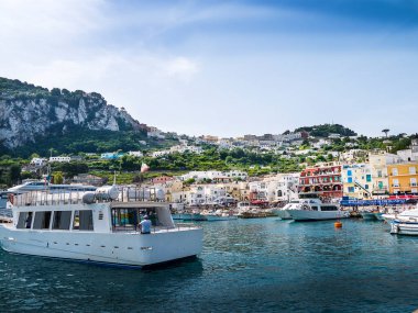 Capri has been a resort island since Roman times . It is situated in the Bay of Naples and is covered with architecture from all the successive generations This is the port on the isle of Capri