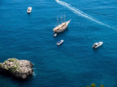 Clifftop view of the sea from the isle of Capri. Capri has been a resort island since Roman times . It is situated in the Bay of Naples and is  a  favorite with boats of all sizes