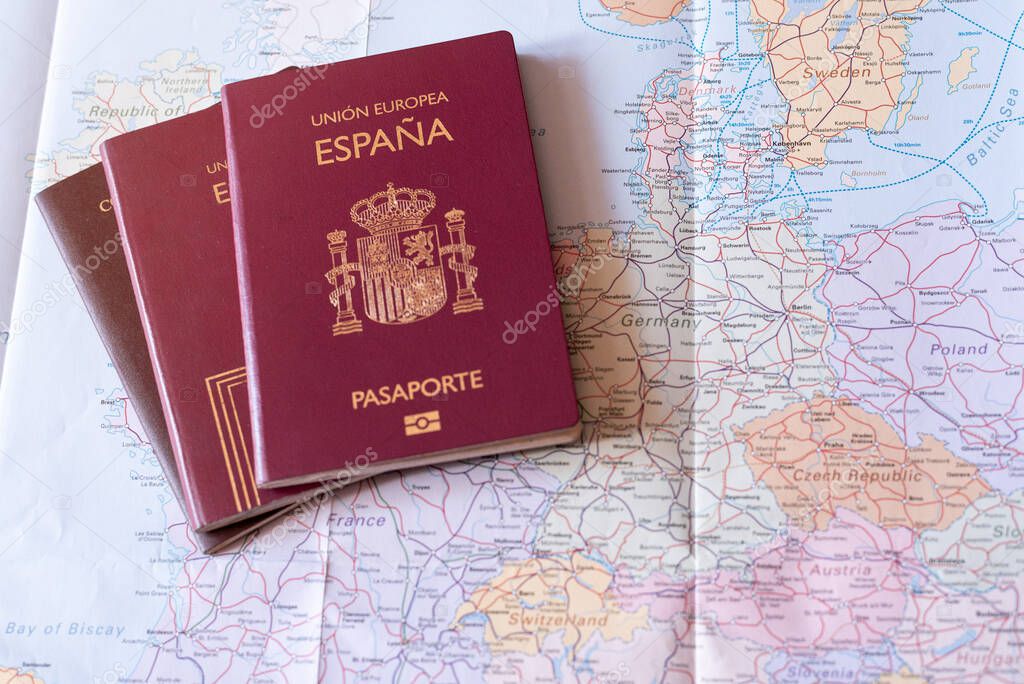 Historic spanish passports over a railway map of european union. Citizenship and trip planning concept with copyspace.