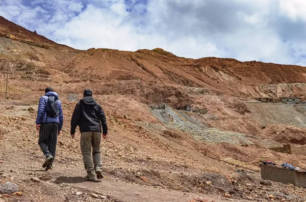 Güney Amerika, Bolivya, Potosi 'deki Cerro Rico gümüş madenlerinde yürüyen erkek turistlerin arka görüntüsü. Latin Amerika 'daki İspanyol fethindeki sömürge sömürüsünün en zengin madeni şehri yoksulluk içinde bıraktı..